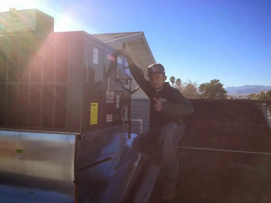 HVAC technician performing AC Tune-Up on a rooftop unit in Billerica